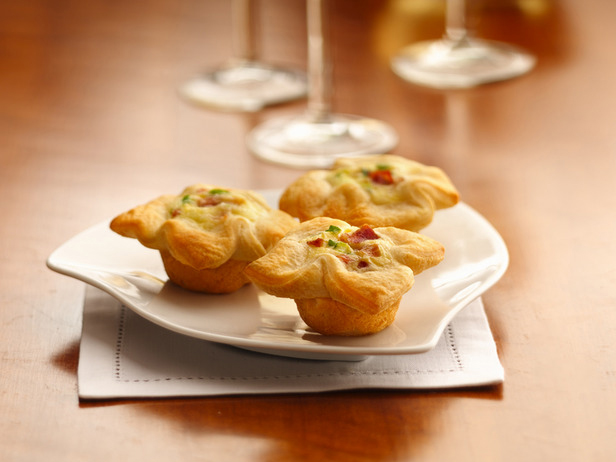 Three Tartlets on a Dish in Front of Three Glasses of White Wine